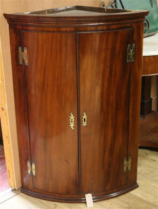 A George III mahogany bow-fronted hanging corner cupboard W.70cm